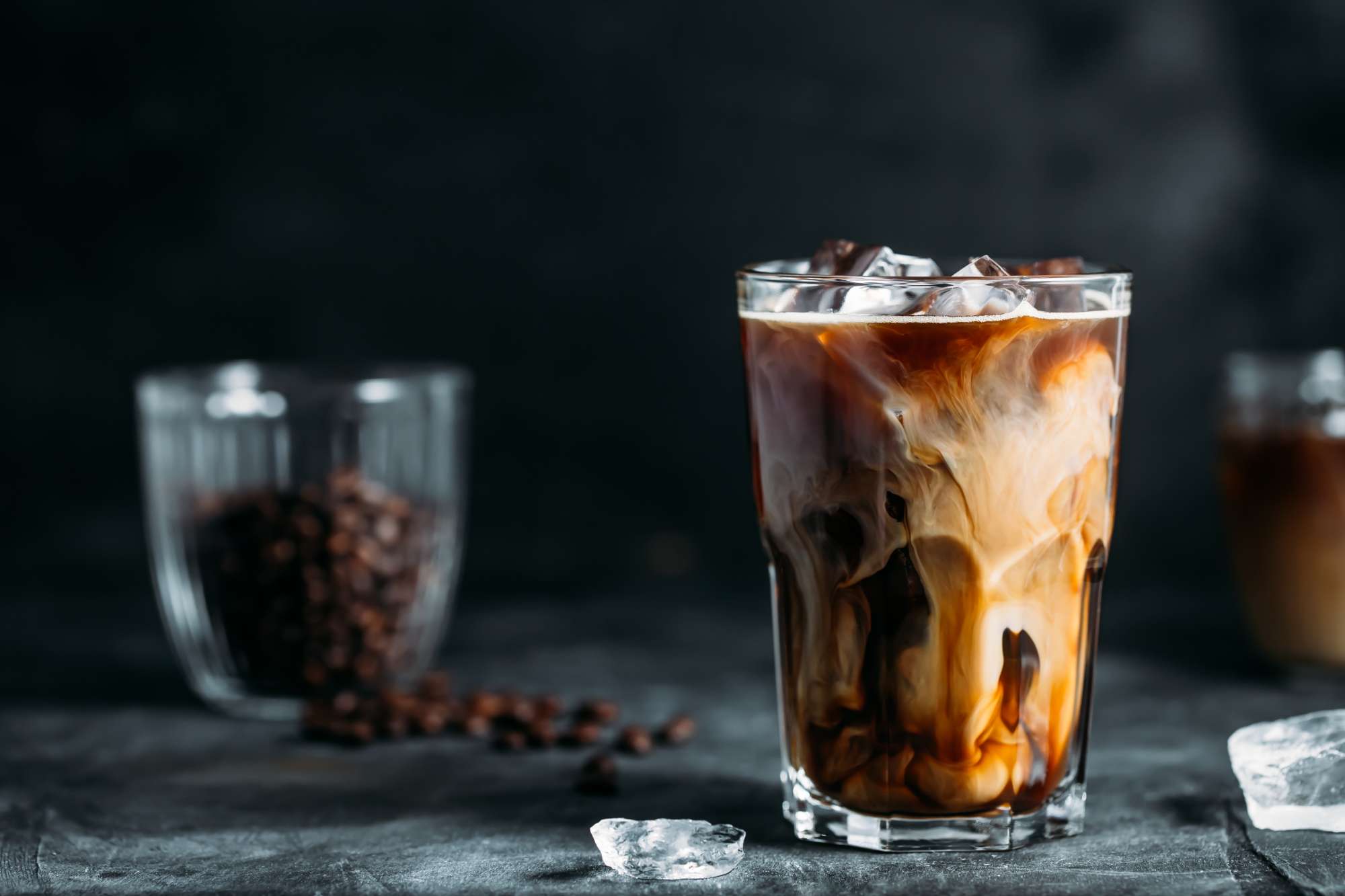 milk-being-poured-into-iced-coffee-dark-table.jpg