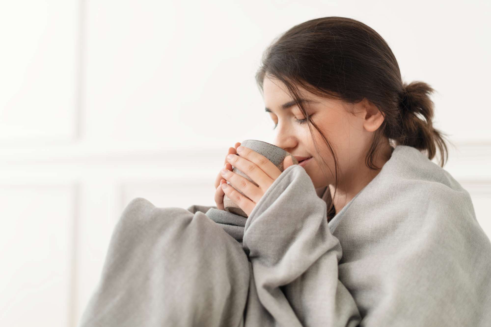 woman-taking-sip-tea-from-mug-during-winter.jpg