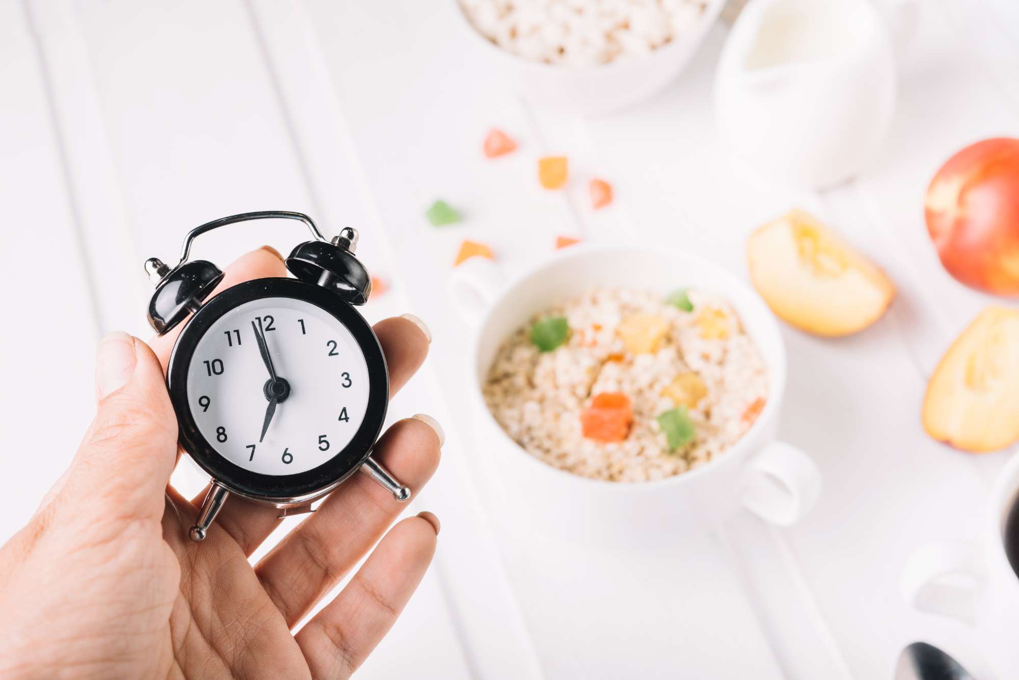 person-s-hand-holding-alarm-clock-hand-breakfast-table-(1).jpg