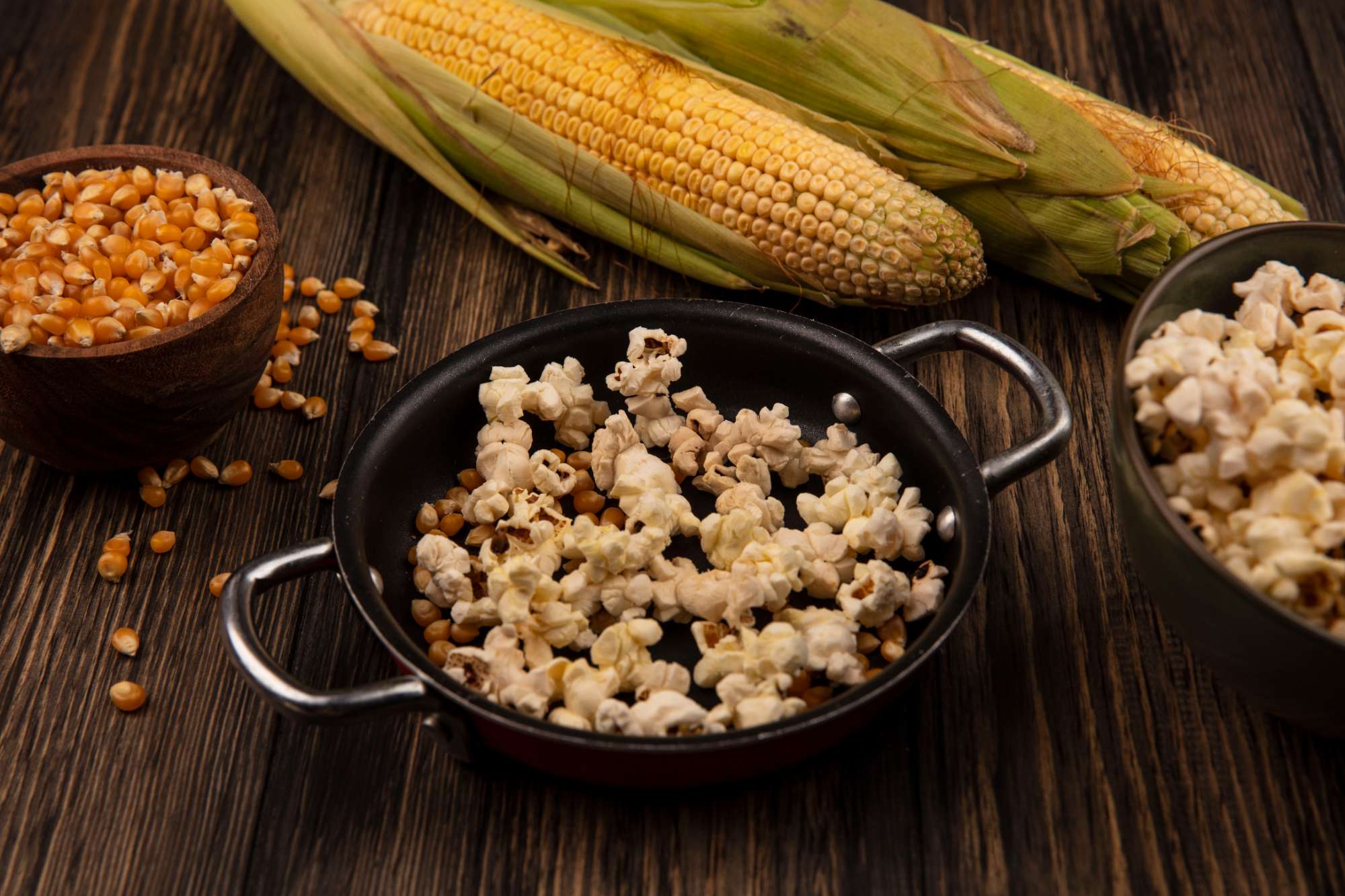 top-view-pan-with-popcorns-with-corn-kernels-with-fresh-corns-isolated-wooden-bowl-wooden-table.jpg