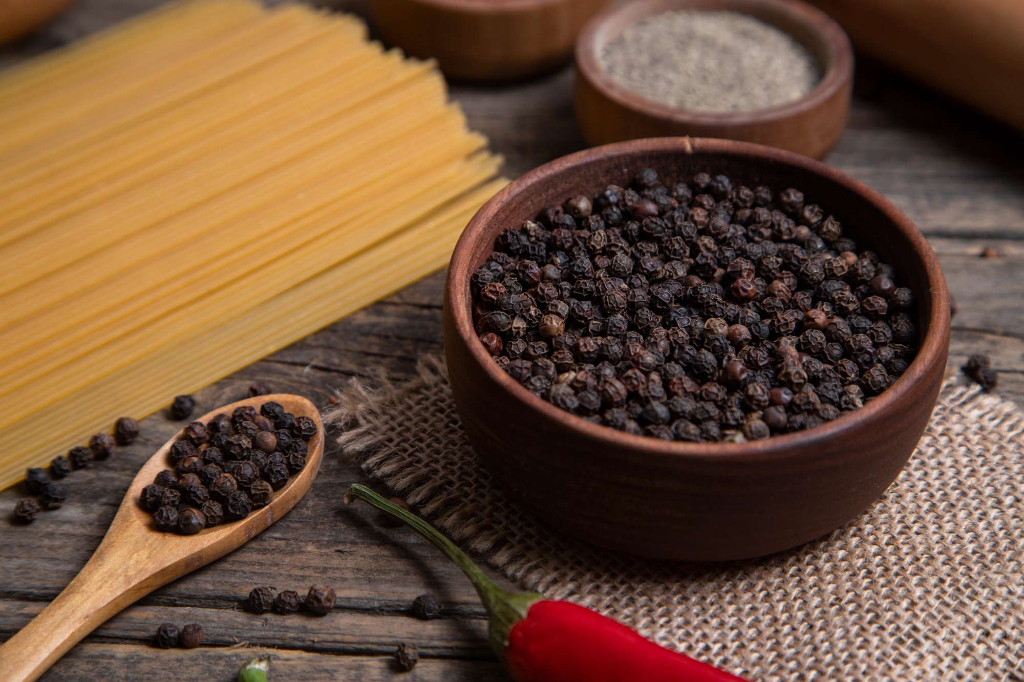 raw-spaghetti-bowl-peppercorns-placed-wooden-surface-high-quality-photo.jpg