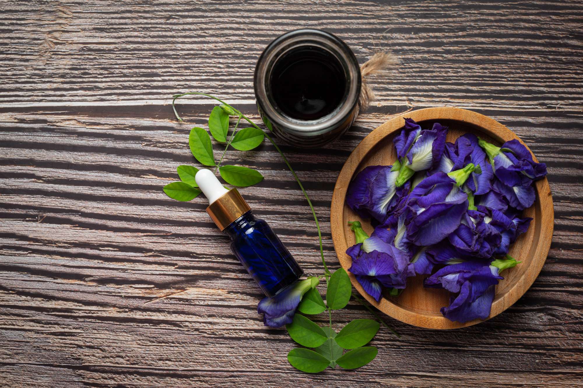 serum-bottle-butterfly-pea-flower-oil-put-wooden-background.jpg