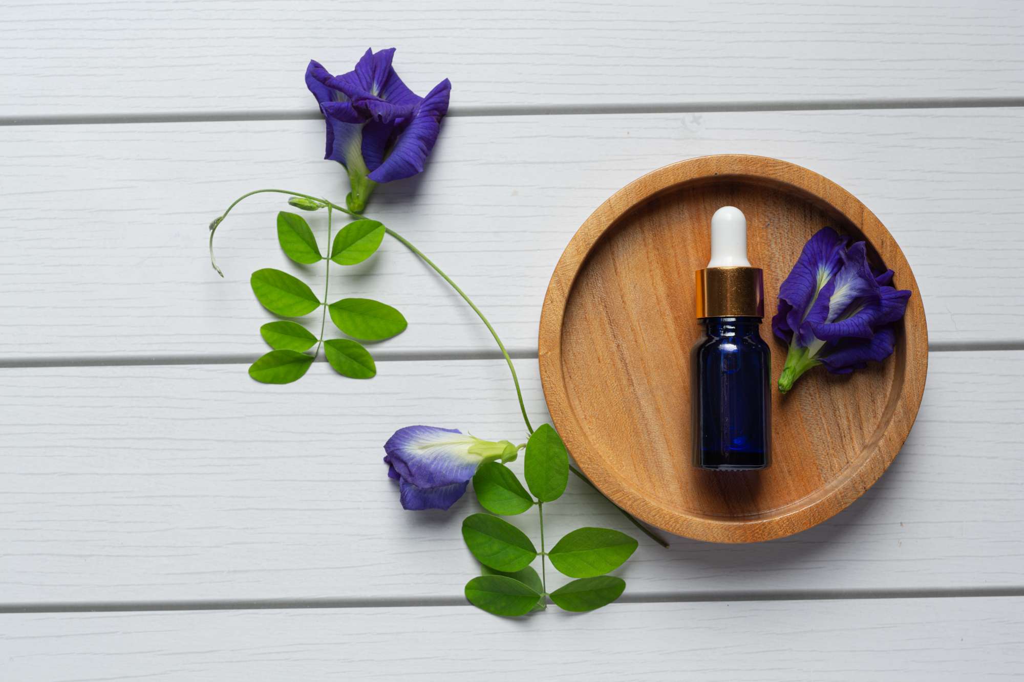 serum-bottle-butterfly-pea-flower-oil-put-wooden-tray.jpg