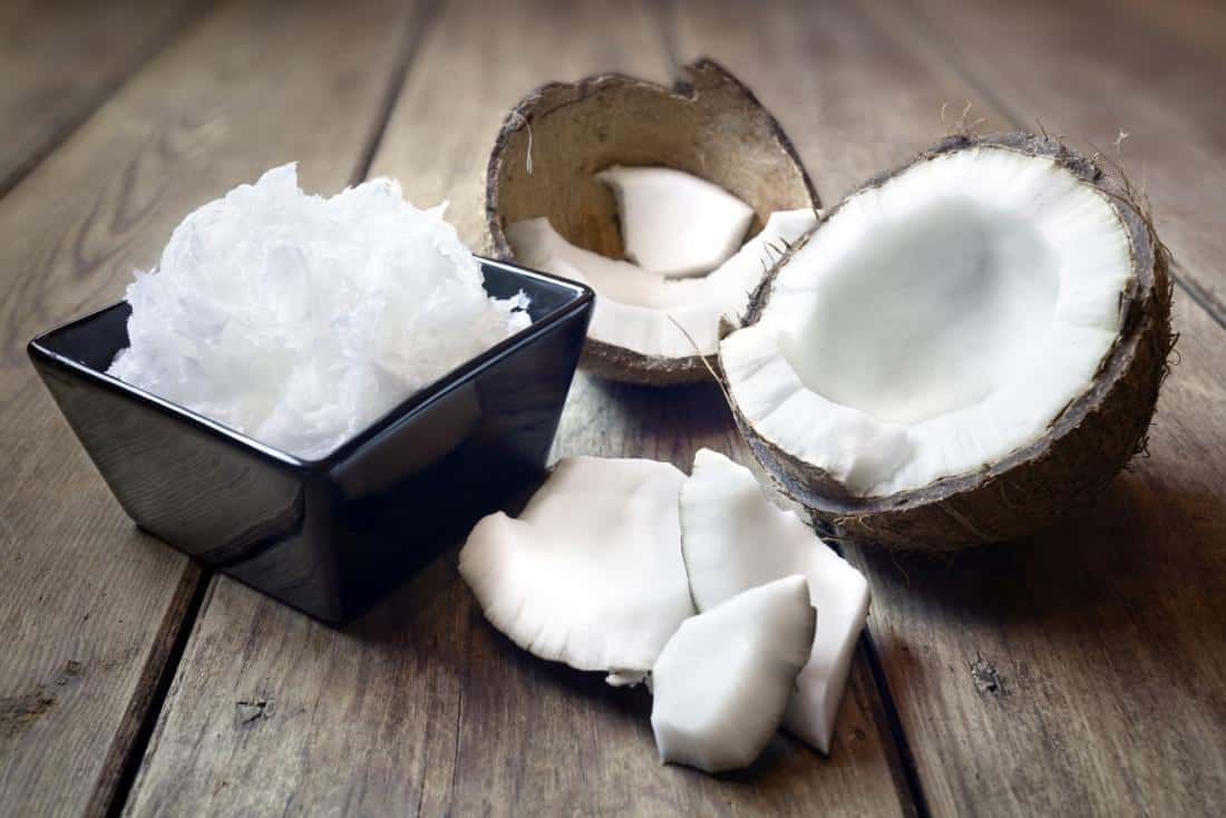 coconut-oil-in-square-black-bowl-with-halved-coconut-and-flesh-for-weight-loss-on-wooden-table.jpg