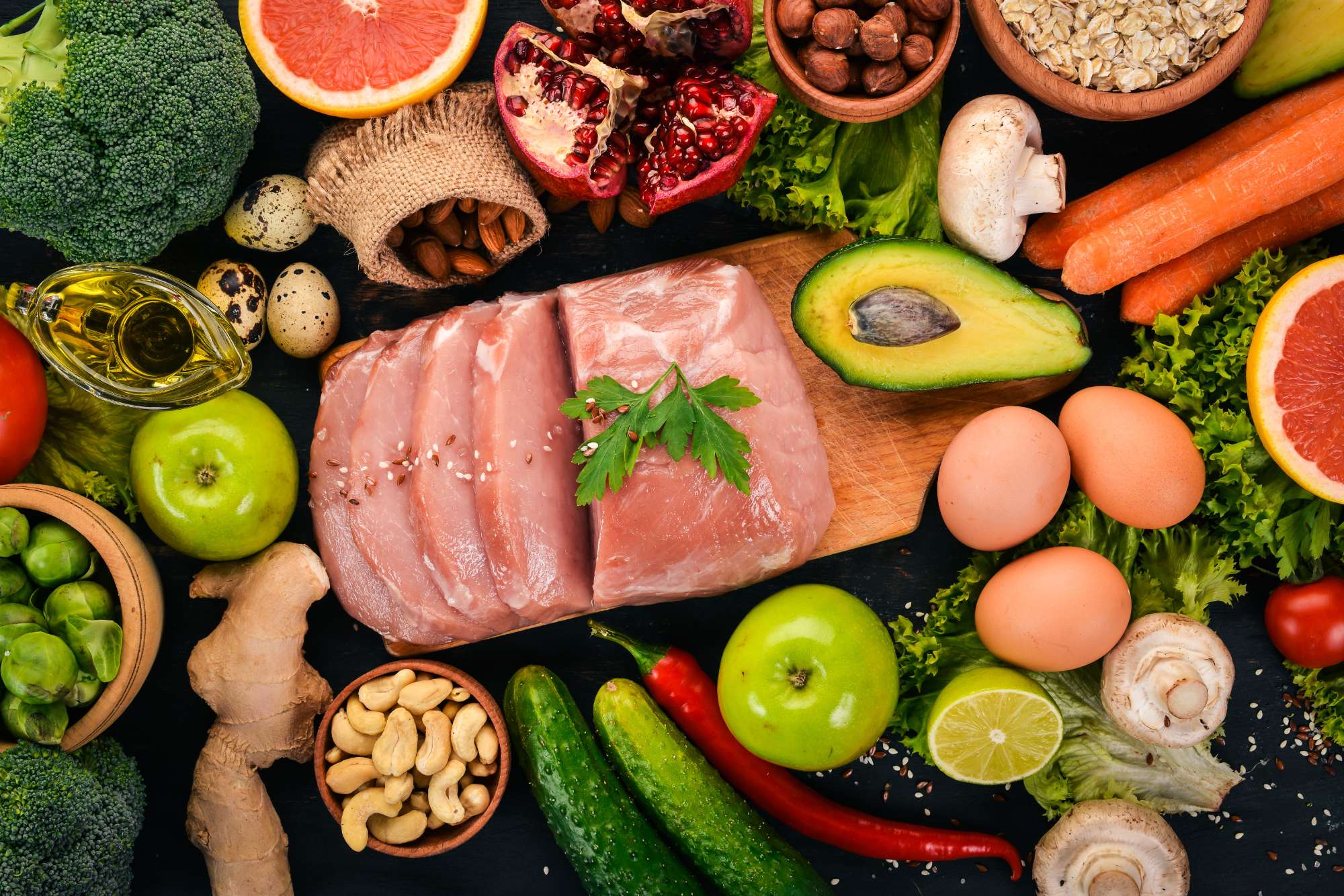 healthy-food-raw-meat-avocado-broccoli-fresh-vegetables-nuts-fruits-wooden-background-top-view-copy-space.jpg