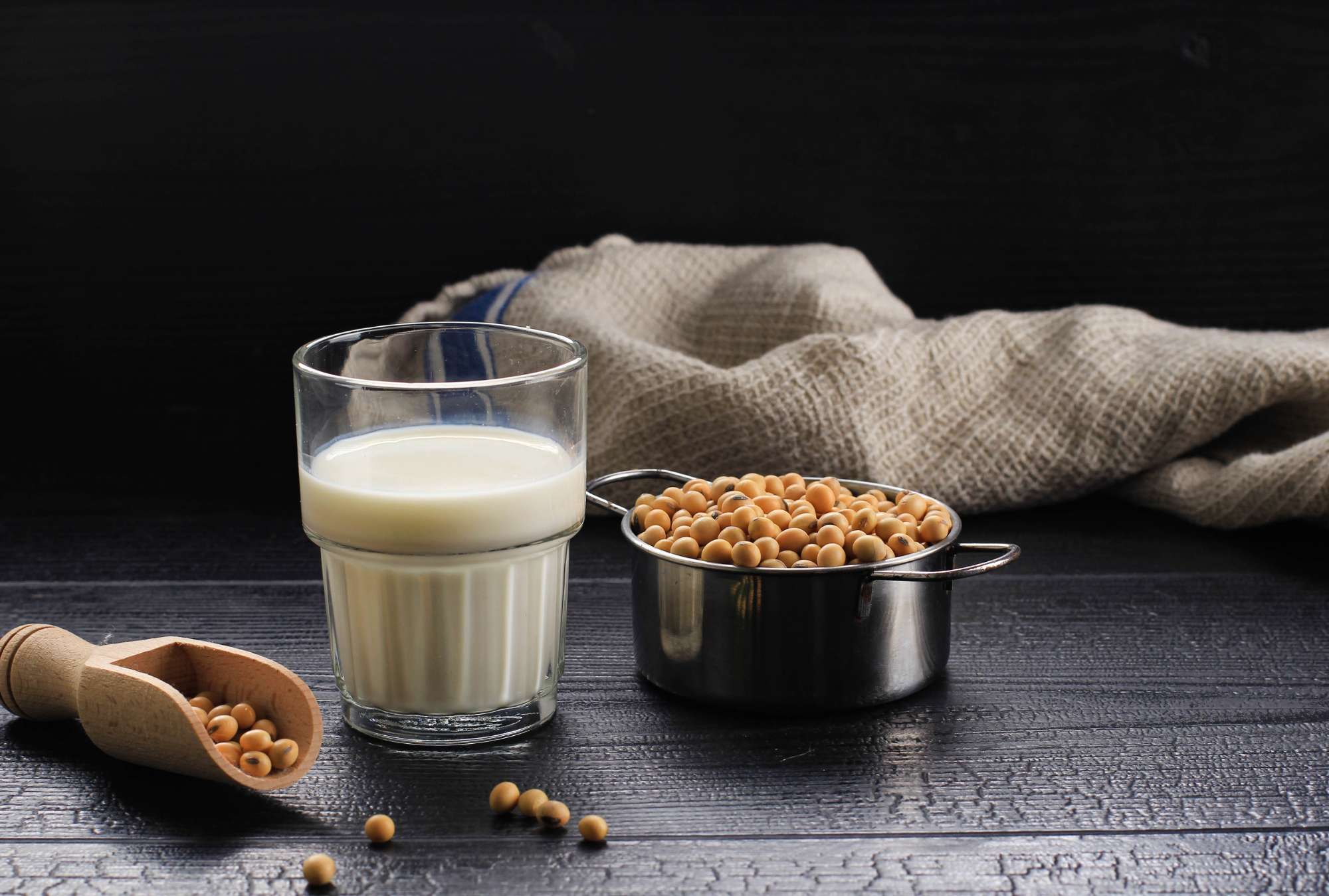 soy-milk-grains-black-wooden-table-rustic-kitchen-background-alternative-milk-concept-front-view.jpg